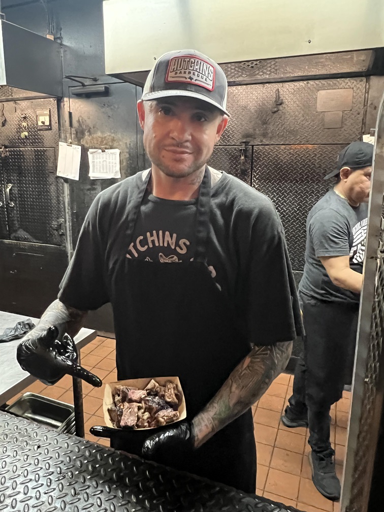 Hutchins BBQ employees put samples into a paper tray to be handed down the line