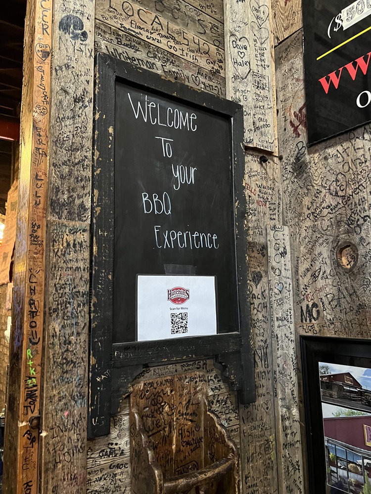 The welcome sign inside Hutchins BBQ with a QR Code to scan for their menu