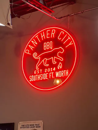 Red neon light sign inside Panther City BBQ